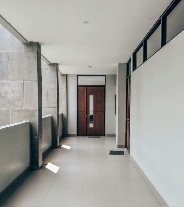 Bright and clean modern hallway in a minimalist apartment, capturing sunlight and shadows.